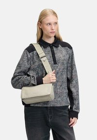 Grau kariertas Schultertasche aus Leder mit strukturierter Oberfläche, ausgestattet mit einem verstellbaren Träger und einer glatten, rechteckigen Form.