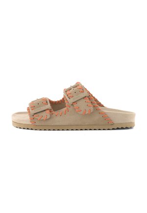 Beige suede slide sandal with two adjustable buckled straps and orange whipstitch detailing along edges and sole.