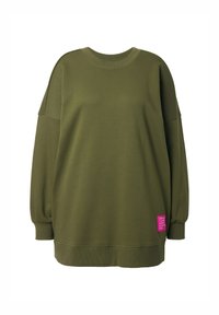 Sweatshirt oversize vert olive en tissu doux avec des épaules tombantes, un col côtelé, et une étiquette en patch rose en bas.