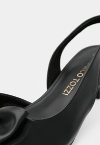 Μαύρο δερμάτινο παπούτσι slingback με στρογγυλή μύτη, με ανοιχτή υφή και λεπτομέρεια σε ρυτίδες στο μπροστινό μέρος.