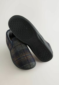 Męskie kapcie w niebiesko-szary wzór w kratkę, miękka podszewka wewnętrzna oraz czarna gumowa podeszwa z teksturowanym wzorem antypoślizgowym.