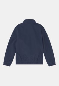 Mörkblå jacka med krage, elastiska ärmslut och midja, i ett smidigt, lätt tyg utan synliga mönster.