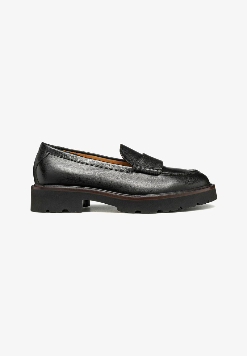 Mocassino in pelle nera con superficie testurizzata, punta arrotondata e suola spessa in gomma nera. Presenta un'accentuazione cucita sopra l'arco del piede.
