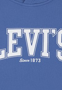 Μπλε ύφασμα hoodie με έντονα λευκά γράμματα "LEVI'S" και "Από το 1873." Λείο ύφασμα, τακτοποιημένη εφαρμογή και χωρίς ορατά σχέδια.