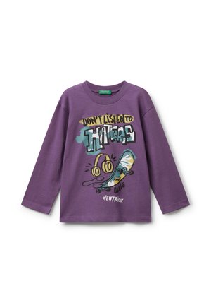 Paarse langwerpige mouwshirt met een afbeelding van hoofdtelefoons, skateboard en de tekst "LUISTER NIET NAAR HATERS," "OLLIE," en "NIEUWE TRUUC."