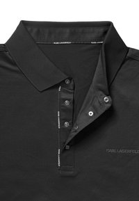 Czarna koszulka polo z gładkiej bawełny z klasycznym kołnierzykiem, listwą na trzy guziki i subtelnym logo na kołnierzyku oraz na listwie.