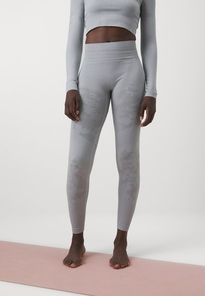 Set de activitate gri deschis, format dintr-o bluză ajustată cu mânecă lungă și colanți cu talie înaltă, ce prezintă un model subtil de camuflaj și o textură țesută.