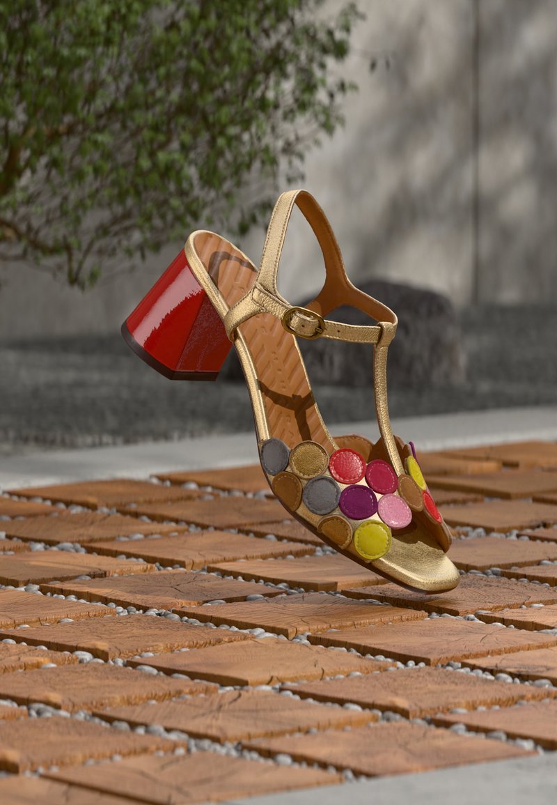 Sandale dorée avec un talon carré rouge, ornée d'accents circulaires en cuir multicolore sur l'avant. Design à brides avec une boucle à la cheville.