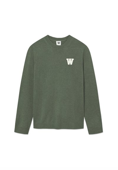 Pull en tricot vert avec un col rond et des manches longues. Présente une lettre "W" blanche sur la poitrine ; ourlet et poignets côtelés.