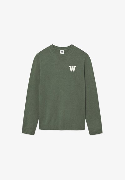 Pull en tricot vert avec un col rond et des manches longues. Présente une lettre "W" blanche sur la poitrine ; ourlet et poignets côtelés.