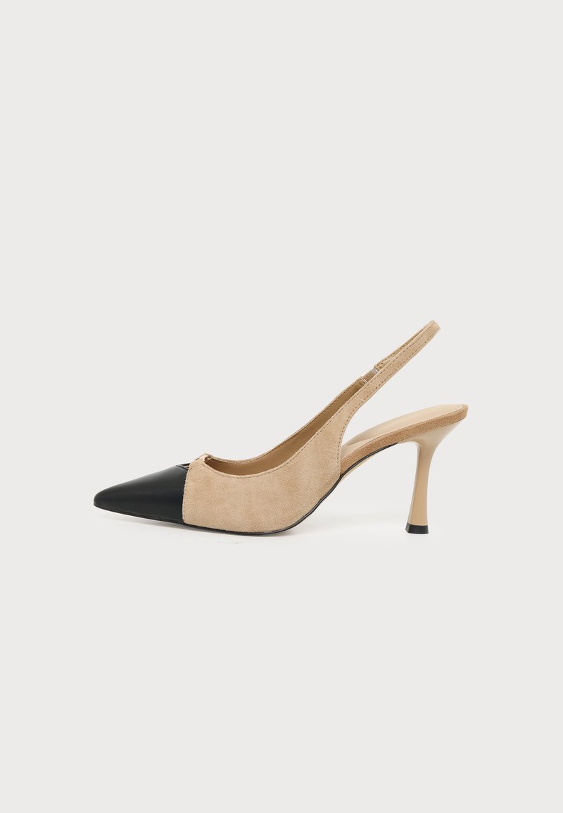Chaussure à talon haut beige en daim avec bride arrière, bout pointu noir et talon fin sur fond blanc uni.