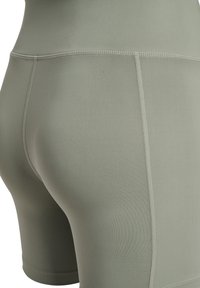 Hochgeschnittene Active-Shorts in gedämpftem Olivgrün, aus glattem, elastischem Stoff mit Flachnähte und tailliertem Design.