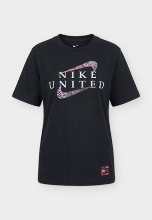 Czarny t-shirt Nike z napisem "NIKE UNITED" i dwoma różowymi wzorzystymi logo Nike Swoosh nakładającymi się na przodzie, plus mała naszywka w pobliżu dołu.