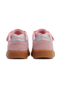 Różowe zamszowe trampki z fakturowaną cholewką, srebrnymi akcentami i gumową podeszwą w kolorze karmelowym. Wyposażone w pasek na rzep dla łatwego zapinania.