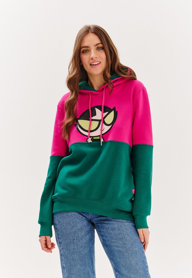 Mikina s kapucí má růžovou horní část a zelenou dolní část, na níž se nachází grafika vtipné postavy, měkkou tkaninu a žebrované manžety.