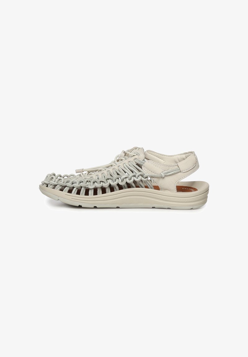 Sandale beige clair à bout ouvert avec dessus en corde tressée, lacet réglable, semelle rembourrée et bride arrière pour un maintien sécurisé, vue de côté.