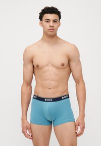 Boxer-briefs pour hommes de couleur bleue avec une ceinture élastique marine comportant le logo "BOSS". Matériau en coton lisse, design ajusté, longueur mi-cuisse.