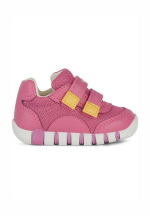 Chaussure de sport rose en matériaux mesh et synthétiques, dotée de deux bandes Velcro, d'une semelle blanche et d'un design nervuré distinct au-dessous.