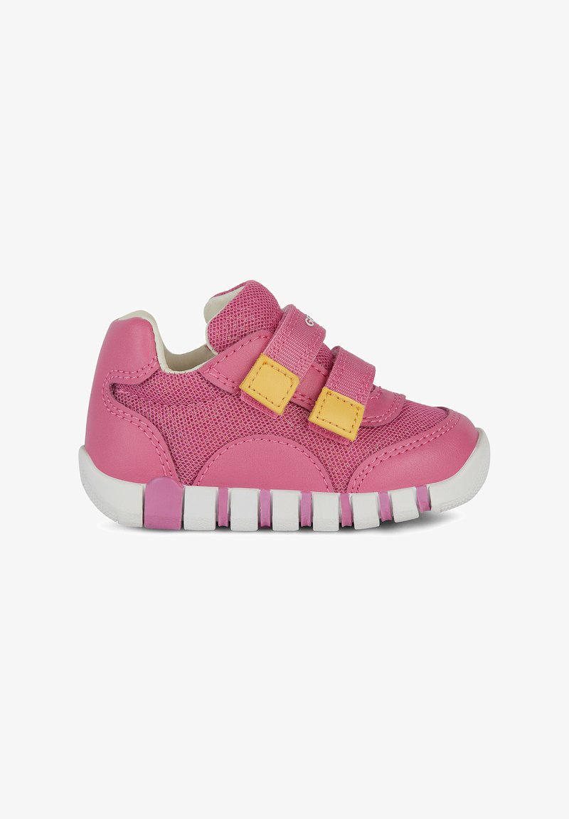 Chaussure de sport rose en matériaux mesh et synthétiques, dotée de deux bandes Velcro, d'une semelle blanche et d'un design nervuré distinct au-dessous.