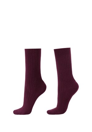 Par de calcetines acanalados hasta media pantorrilla en color burdeos intenso, mostrados uno al lado del otro sobre un fondo blanco.