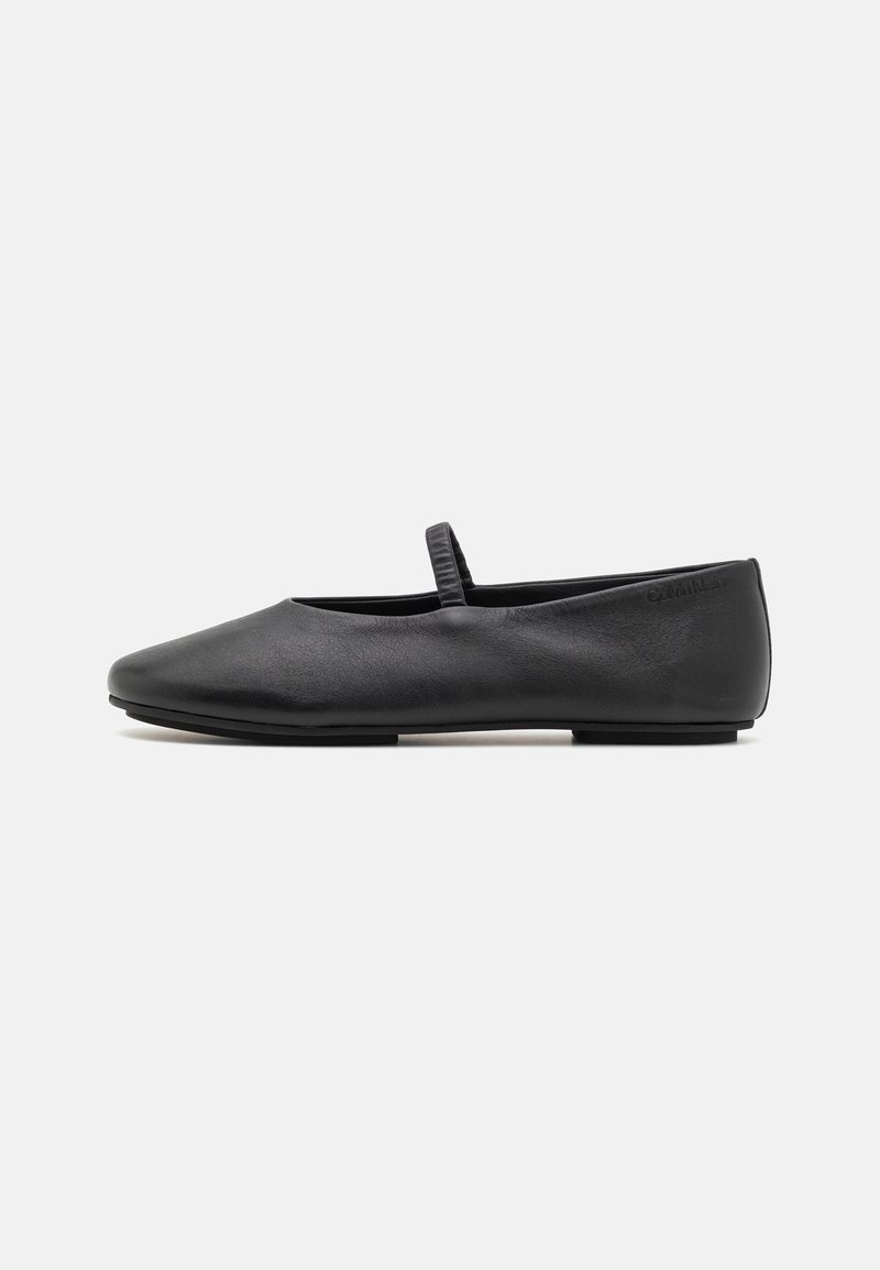 Chaussure plate Mary Jane noire avec une seule bride élastique sur le cou-de-pied, dessus en cuir lisse et semelle basse.