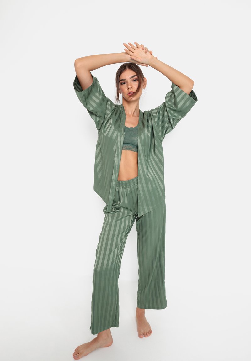 Groene gestreepte pyjama set van soepel materiaal; losse top met brede mouwen, bijpassende broek met elastische tailleband, minimalistisch ontwerp.
