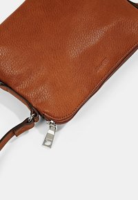 Bruine leren clutch met een gestructureerd oppervlak, ritssluiting en een zilveren trekker. Inclusief een afneembare schouderband voor het dragen.