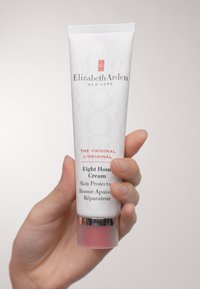 Krem Eight Hour firmy Elizabeth Arden w białej tubie z czerwonymi akcentami, z metaliczną podstawą. Teksturowany z błyszczącym wykończeniem i wytłoczonymi logo.