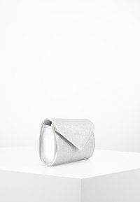 Srebrna torebka kopertówka z połyskującym brokatem, z klapą zapinaną na zagięcie, gładką powierzchnią, miękką strukturą i zaokrąglonymi krawędziami, zaprojektowana do kompaktowego przechowywania.
