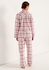Katoenen pyjamapakket met een wit en roze ruitpatroon, lange mouwen en een knoopsluitingshirt met bijpassende loszittende broek.