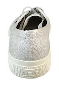 Srebrny sneakers z teksturą, z białą gumową podeszwą, z sznurówkami i brandingiem z tyłu. Wierzch ma subtelny splatany wzór.