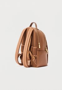 Brown leather backpack with textured surface, two zippered compartments, and adjustable padded straps. Features gold-tone hardware and side pocket.