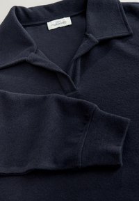 Tumesinine rasedustooted polo särk tekstureeritud kangaga, klassikalise krae ja pikkade varrukatega. Silt ütleb "Next Maternity."