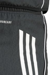 Zwarte sportbroek met een gestructureerde stof, witte accentstrepen en een logo opvallend weergegeven bij de tailleband.