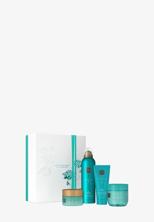 Gift set with four turquoise cosmetic containers, including a gold-lidded jar, spray bottle, and two tubes, presented in a white embossed box.