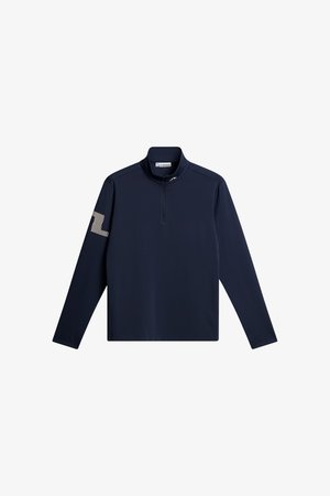 Granatowy długi rękaw z półzamkiem i stójką, z białym paskowanym logo "JL" na lewym rękawie.