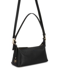 Sac d'épaule rectangulaire noir avec deux sangles, fermeture éclair dorée et petite garniture décorative dorée sur fond blanc.