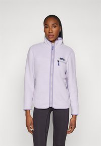 Fleece jacket in licht lavendel met een hoge kraag, ritssluiting aan de voorkant, zijvakken en een klein borstzakje, met contrasterende ritsaccenten.