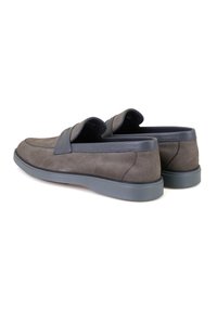 Chaussures slip-on en suede gris avec un accent en cuir lisse, bout arrondi et semelle en caoutchouc, présentant un design épuré et un style minimaliste.
