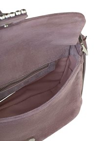 Interno della borsa a tracolla in suede viola con una texture liscia, dotato di una tasca con zip e di un comparto principale. Accenti in metallo argentato.