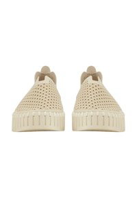 Scarpe slip-on beige con un design perforato, suola in gomma testurizzata, punta arrotondata e cuciture sottili lungo il bordo della suola.