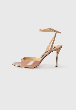 Nude patent leather high-heeled sandals with a peep toe, thin ankle strap, and a stiletto heel. Smooth texture and minimalist design.