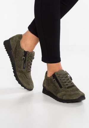 Baskets en daim vert olive avec design perforé, devant à lacets, accent zippé sur le côté et semelle en caoutchouc noir texturée.