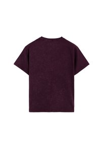 Camiseta morada de manga corta en una tela suave y texturizada. Cuenta con cuello redondo y un ajuste holgado y cuadrado con una costura vertical en la espalda.