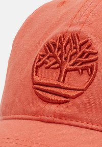 Casquette en coton ornée d'un logo d'arbre brodé. Présente un visière courbée et des accents cousus. Texture lisse.