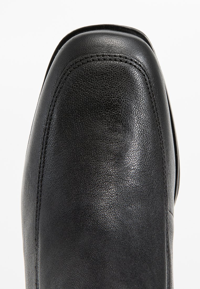 Chaussure formelle en cuir noir avec une pointe carrée arrondie et des détails de double couture le long du bord avant, vue de dessus.