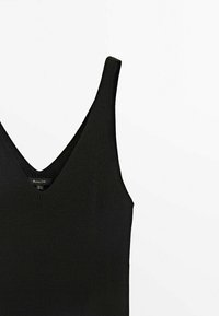 Schwarzes, geripptes Tanktop mit V-Ausschnitt, schmalen Trägern und einem strukturierten Stoff. Etikett am Ausschnitt sichtbar. Einfaches Design, einfarbig.
