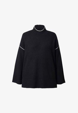 Musta neule, jossa on korkea kaulus ja löysä istuvuus. Siinä on valkoista kontrastiväristä ompelua kauluksessa ja hihoissa, neulottu pinta ja resorimainen helma.