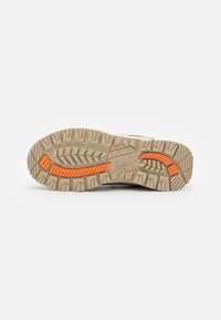 Helle beige Schuhsohle mit tiefen Profilrillen und orangefarbenen Akzenten. Strukturierte Oberfläche mit einer Mischung aus gemusterten und flachen Bereichen für besseren Halt.