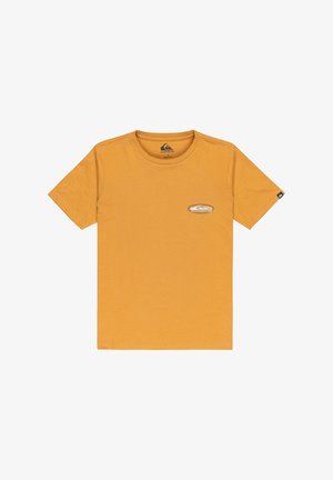 Camiseta de manga corta amarilla mostaza con pequeño logo de Quiksilver en el lado izquierdo del pecho y una pequeña etiqueta negra en la manga derecha.